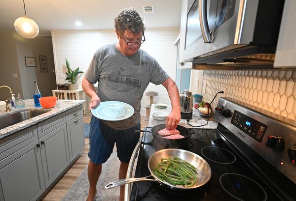 Chris Hughes, who is an out-of-work chef, cooks pan-seared Covina with vegetables at his home trying to keep his skills up as he looks for work on Tuesday, August 25, 2020. (Hyosub Shin / Hyosub.Shin@ajc.com)