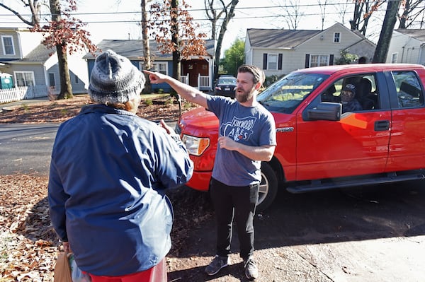 Ida James (left) explains her repair needs to Justin Schaeffer (center) as Woodrow Williams (right) looks from her truck in Kirkwood neighborhood. Schaeffer helps run an organization called Kirkwood Cares.  (Hyosub Shin / Hyosub.Shin@ajc.com)