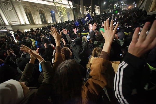 Demonstrators stand in front of police during a rally outside the parliament's building to protest the government's decision to suspend negotiations on joining the European Union for four years in Tbilisi, Georgia, on Saturday, Nov. 30, 2024. (AP Photo/Zurab Tsertsvadze)