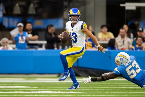 Los Angeles Rams quarterback Stetson Bennett (13) runs with the ball past Los Angeles Chargers linebacker Chris Collins (53) during an NFL preseason football game, Saturday, Aug. 17, 2024, in Inglewood, Calif. (AP Photo/Kyusung Gong)