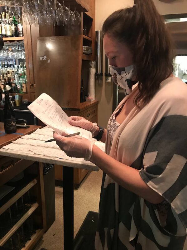 Emily James enters orders at Osteria Mattone in Roswell. During normal times, she would be managing the bar at sister restaurant Coalition Food and Beverage in Alpharetta. LIGAYA FIGUERAS / LIGAYA.FIGUERAS@AJC.COM