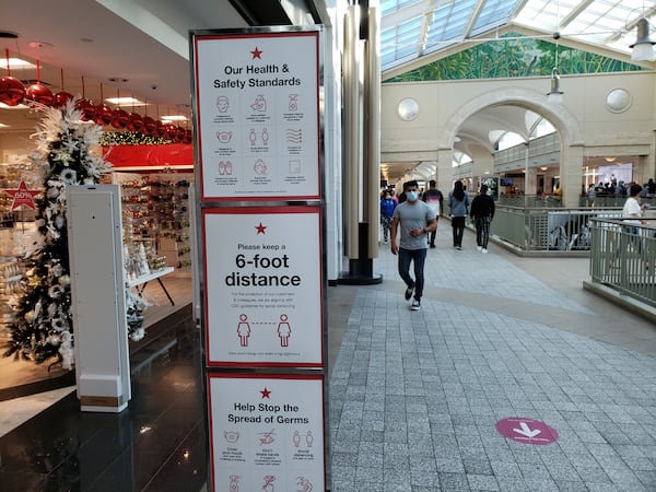 Retailers, such as Macy's at Lenox Square mall in Atlanta, are encouraging shoppers to comply with pandemic-related safety measures amid the holiday shopping season. MATT KEMPNER / AJC