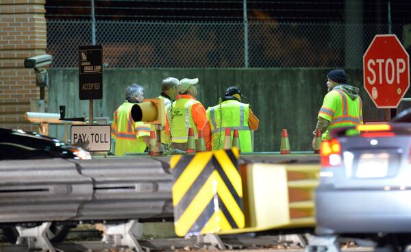 Road crews work as Georgia Department of Transportation closes two northbound lanes near Georgia 400 toll booths on Oct. 25, 2013. HYOSUB SHIN / HSHIN@AJC.COM