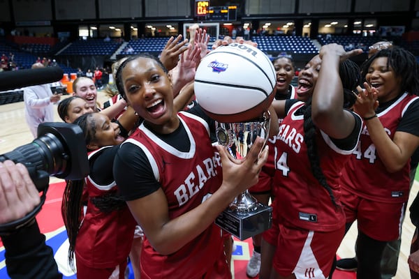 Holy Innocents’ guard Hailee Swain holds the trophy after her team's dominant state championship win.