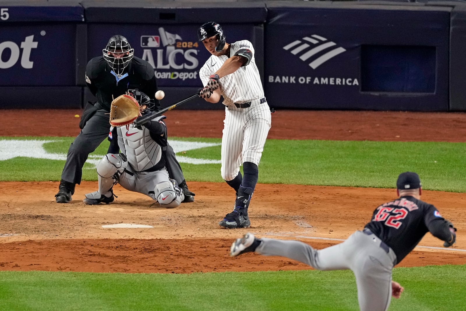 New York Yankees' Giancarlo Stanton, center, hits a home run off Cleveland Guardians relief pitcher Erik Sabrowski (62) during the seventh inning in Game 1 of the baseball AL Championship Series Monday, Oct. 14, 2024, in New York. (AP Photo/Seth Wenig)