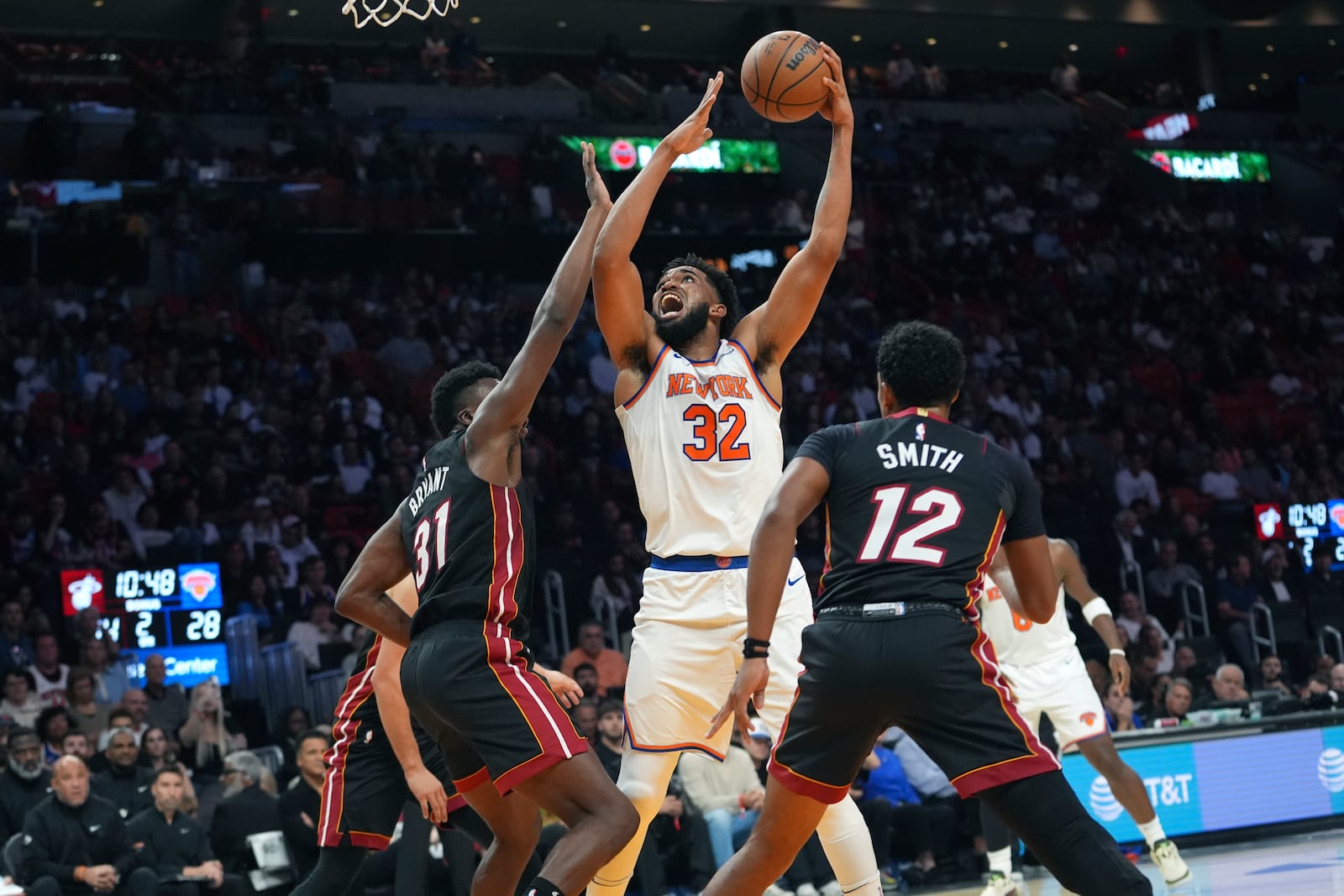 New York Knicks center Karl-Anthony Towns (32) goes to the basket as Miami Heat center Thomas Bryant (31) defends during the first half of an NBA basketball game, Wednesday, Oct. 30, 2024, in Miami. (AP Photo/Lynne Sladky)