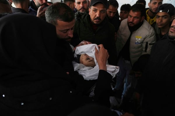 Mourners carry the bodies of Palestinians including children who were killed by an Israeli army airstrike, at the Baptist Hospital in Gaza city, Friday, March 21, 2025. (AP Photo/Jehad Alshrafi)