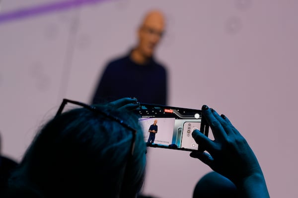 An attendee at the Microsoft Ignite conference records CEO Satya Nadella as he delivers the keynote address at the conference Tuesday, Nov. 19, 2024, in Chicago. (AP Photo/Charles Rex Arbogast)