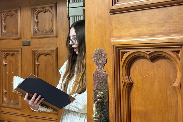 A tour guide at New Zealand's Parliament gives a spooky tour of the historical Parliament library, constructed in the late 19th century and rumored to be haunted, in Wellington, Thursday, March 20, 2025. (AP Photo/Charlotte Graham-McLay)