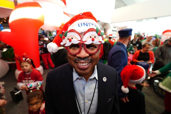 A United Airlines employee dons holiday spectacles during the United Airlines annual "fantasy flight" to a fictional North Pole at Denver International Airport, Saturday, Dec. 14, 2024, in Denver. (AP Photo/David Zalubowski)