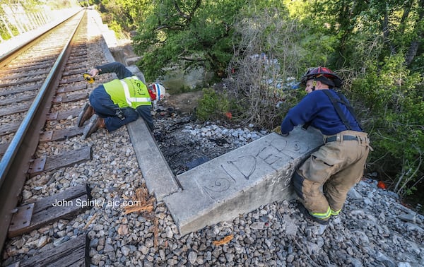 A CSX employee and Atlanta fire Capt. Eric Banaszek took  measurements of the bridge after the blaze. JOHN SPINK / JSPINK@AJC.COM