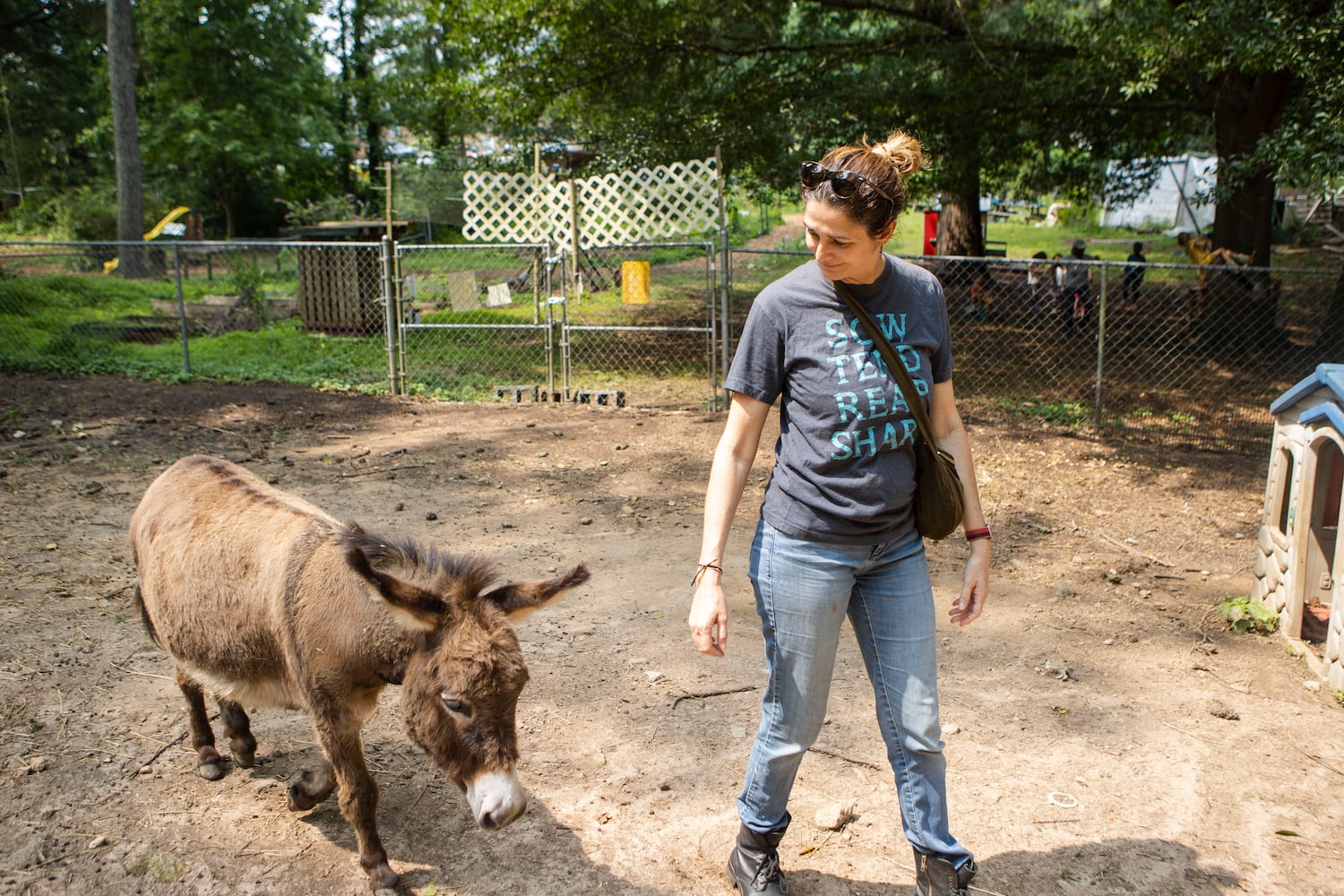 Judy Byler, founder and CEO of Our Giving Garden, walks with one of the donkeys living at Our Giving Garden on Wednesday, June 7, 2023, in Mableton, Georgia. Our Giving Garden is a nonprofit community garden that donates fresh produce to families without access to it. CHRISTINA MATACOTTA FOR THE ATLANTA JOURNAL-CONSTITUTION.