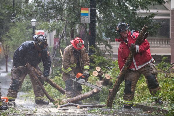 Atlanta firefighters work to clear a downed tree on 14th Street near Peachtree Street in downtown Atlanta, Monday, Sept. 11, 2017.  BRANDEN CAMP/SPECIAL