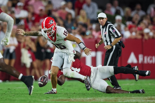 Georgia quarterback Carson Beck (15) fumbles the ball as Alabama linebacker Qua Russaw (4) tackles him during the second half at Bryant-Denny Stadium, Saturday, Sept. 28, 2024, in Tuscaloosa, Al. Georgia lost the fumble on the play. Alabama won 41-34. (Jason Getz / AJC)

