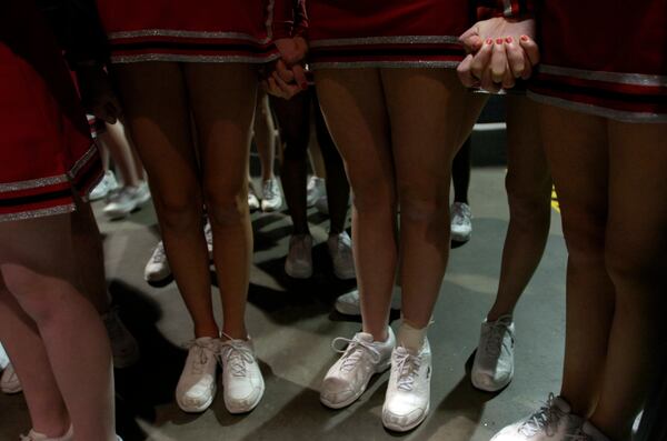 Cheerleaders hold hands before the Cheersport National Championship on Feb. 17, 2017, at the Georgia World Congress Center. Cheersport is one of the national competitions affiliated with Varsity Brands, which is a defendant in a lawsuit filed this month alleging a teenage male cheerleader was sexually abused by a former coach at a Marietta gym. (2017 AJC file photo)