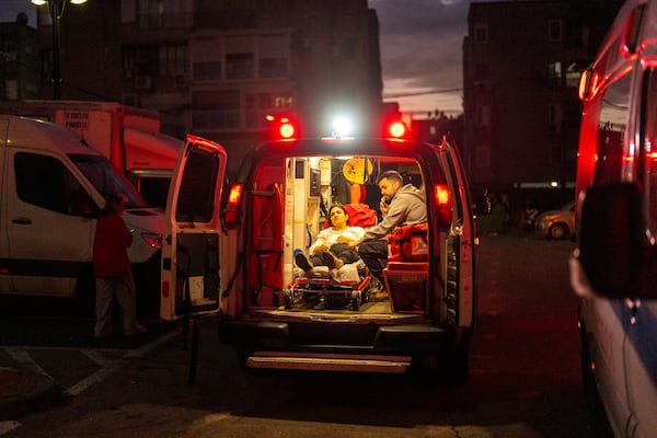 A woman rests in an ambulance at the site where a rocket, fired from Lebanon, hit a kindergarten in Acre, northern Israel, Wednesday, Nov. 20, 2024. (AP Photo/Francisco Seco)