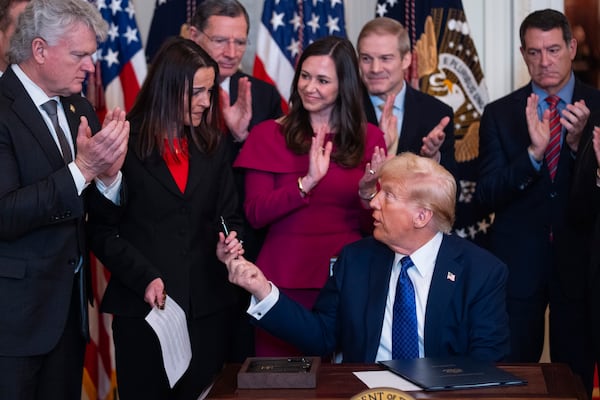 President Donald Trump hands a pen to Allyson Phillips, mother of Laken Riley, after signing the Laken Riley Act at the White House on Wednesday. Georgia U.S. Rep. Mike Collins of Jackson (far left) was the primary author of the bill. 