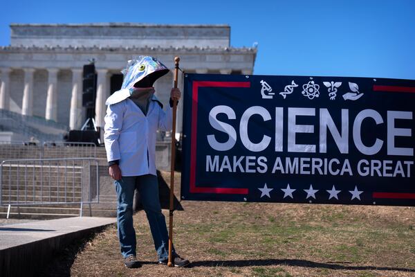 A protestor wearing a fish costume holds a sign reading "Science Makes America Great" as demonstrators gather for the Stand Up For Science rally near the Lincoln Memorial, Friday, March 7, 2025, in Washington. (AP Photo/Mark Schiefelbein)