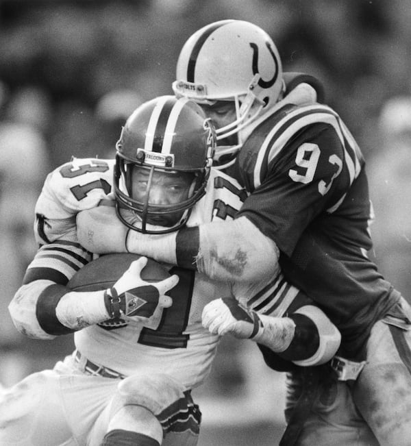 William Andrews is tackled by the Colts' Cliff Odom in 1986.  Odom played 13 years in the NFL. His son Chris Odom re-signed with the Falcons on Tuesday. He has a chance to make the roster in 2019. AJC file photo