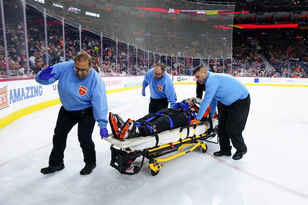 Referee Mitch Dunning, center, is stretchered off the ice after an injury during the first period of an NHL hockey game between the Philadelphia Flyers and the Colorado Avalanche, Monday, Nov. 18, 2024, in Philadelphia. (AP Photo/Derik Hamilton)