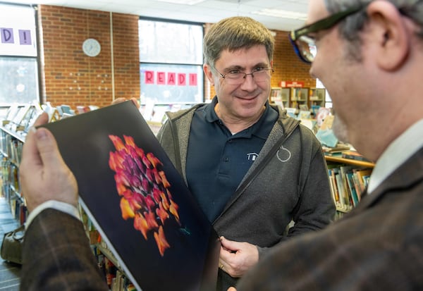 Peachtree Corners Photography Club member Jim Skurski (left) chats with Brian Walton about his photo that is on display at the Peachtree Corners Branch Library. PHIL SKINNER FOR THE ATLANTA JOURNAL-CONSTITUTION