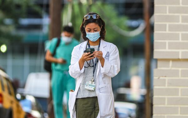 In this recent photo, Dr. Karen Law and medical workers move between buildings at Grady Memorial Hospital in downtown Atlanta. (John Spink / John.Spink@ajc.com)

