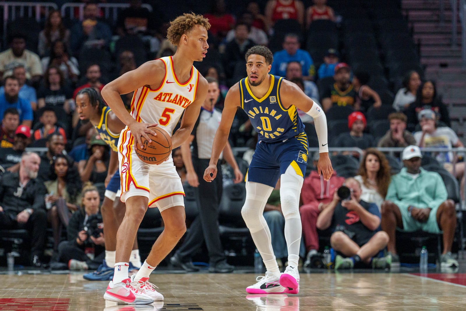 Atlanta Hawks guard Dyson Daniels (5) looks for an open teammate while guarded by Indiana Pacers guard Tyrese Haliburton (0) during the first half of a preseason NBA basketball game, Tuesday, Oct. 8, 2024, in Atlanta. (AP Photo/Jason Allen)