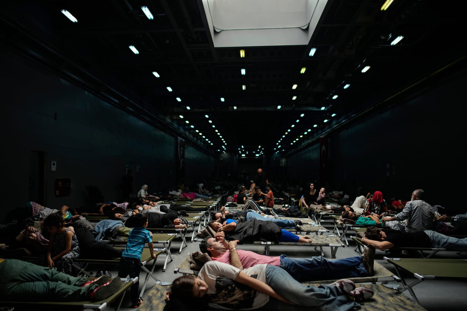 People, mostly Turkish citizens, rest on board of a Turkish military ship evacuating them from Lebanon to Turkey, in Beirut port, on Thursday, Oct. 10, 2024. (AP Photo/Emrah Gurel)