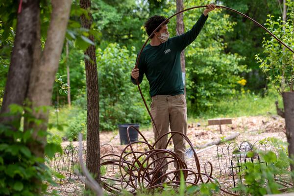 04/29/2020 - Atlanta, Georgia  - Mike McCord, food forest ranger for Trees Atlanta, prepares a waterline for drip irrigation at the Urban Food Forest at Browns Mill Community Garden in Atlanta's Lakewood community, Wednesday, April 29, 2020. (ALYSSA POINTER / ALYSSA.POINTER@AJC.COM)