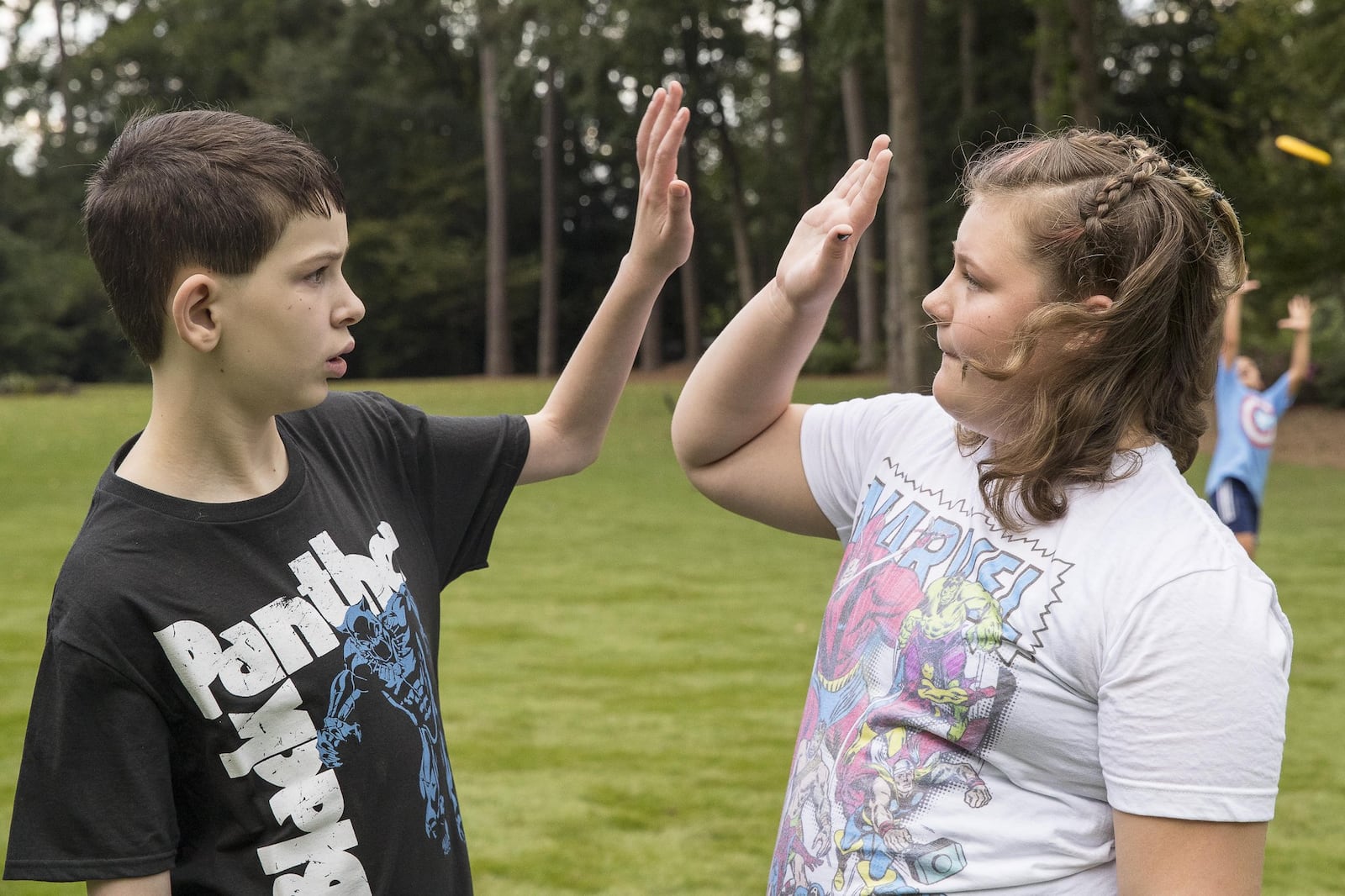 Avery Delaney and his little sister Grace give each other a high-five while hanging out. ALYSSA POINTER / ALYSSA.POINTER@AJC.COM