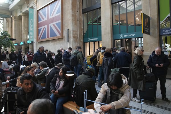 Travelers wait as Eurostar trains to London and all trains heading to northern France have been brought to a halt following the discovery of an unexploded bomb dating back to World War II near the tracks, Friday, March 7, 2025 at the Gare du Nord station in Paris. (AP Photo/Christophe Ena)