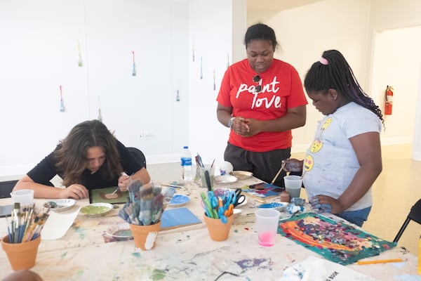 Chloe Young works with Emily Stevens, 13 (L) and Nydia Jones, 9 (R) on a self-portrait project around the theme of self expression.