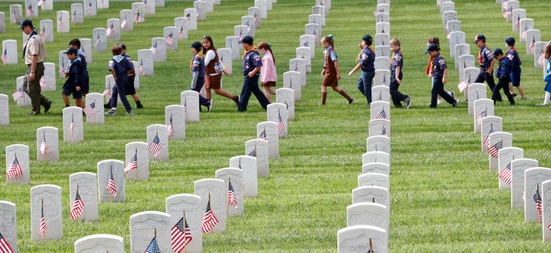 scouts place flags at veteran graves to honor memorial day