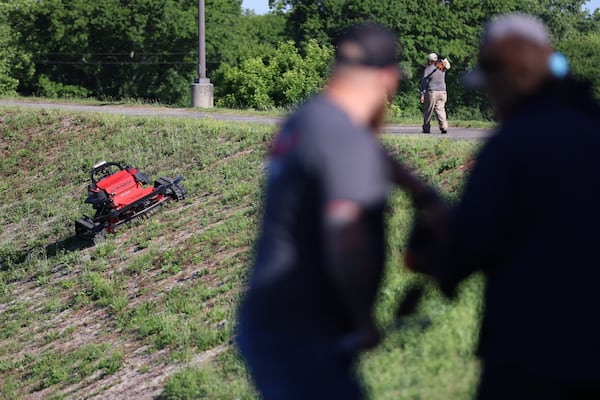 A few people work with a remote-controlled driverless lawnmower during a Department of Public Works and Watershed Management demonstration on Thursday, Mat 12, 2022. This new and innovative method of the department will work on mowing steep slopes, inclines, and hazardous terrain safely and efficiently. Miguel Martinez / miguel.martinezjimenez@ajc.com