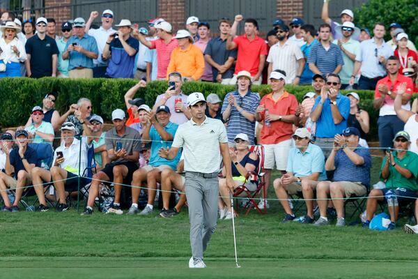 The crowd reacts after Joaquin Niemann made an eagle putt on the eighteenth green during the second round of the Tour Championship at East Lake Golf Club, Friday, August 26, 2022, in Atlanta. (Jason Getz / Jason.Getz@ajc.com)