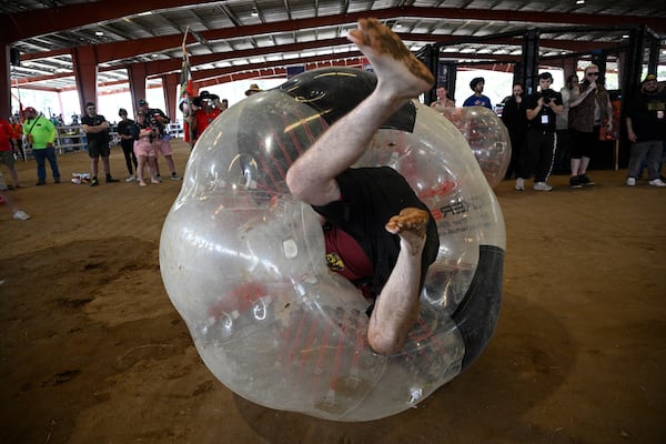 Pierce Beauregard, of Gainesville, Fla., rolls on the ground after getting bounced by a competitor in the Human Beer Pong competition during the Florida Man Games, Saturday, March 1, 2025, in Elkton, Fla. (AP Photo/Phelan M. Ebenhack)