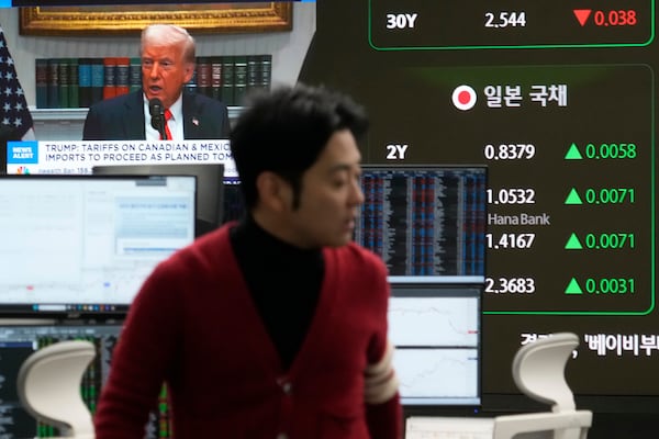 U.S. President Donald Trump is seen on a screen as a trader works at the foreign exchange dealing room of the KEB Hana Bank headquarters in Seoul, South Korea, Tuesday, March 4, 2025. (AP Photo/Ahn Young-joon)