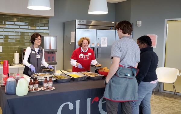 CURE staff members Karen Rutherford (second from left) and Rhetta Ascari serve lunch in the family room of the Aflac Cancer and Blood Disorders Center at Children’s Healthcare of Atlanta at Scottish Rite. CONTRIBUTED