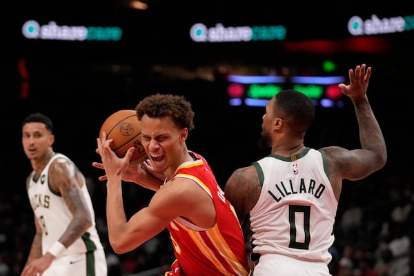 Atlanta Hawks guard Dyson Daniels (5) tries to shoot against Milwaukee Bucks guard Damian Lillard (0) in the first half of an NBA basketball game, Tuesday, March 4, 2025, in Atlanta. (AP Photo/Brynn Anderson)