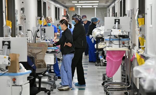 Health workers work on mobile medical units in the hallway of the temporary COVID-19 ICU at Northeast Georgia Medical Center in Gainesville on Wednesday. (Hyosub Shin / Hyosub.Shin@ajc.com)