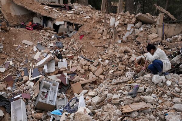 Lina Rida Jawhari, cries as she sits on the rubble of her family's destroyed house in Baalbek, eastern Lebanon, Thursday, Nov. 28, 2024. (AP Photo/Hassan Ammar)