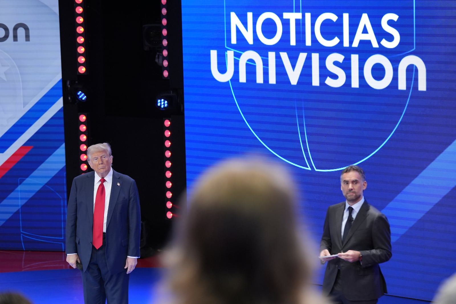 Republican presidential nominee former President Donald Trump listens to an audience question during a Univision town hall, Wednesday, Oct. 16, 2024, in Doral, Fla., with Televisa's Enrique Acevedo, standing right. (AP Photo/Alex Brandon)