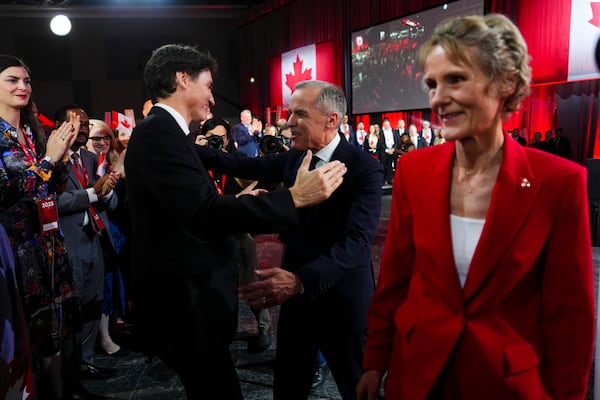 Liberal Party of Canada Leader Mark Carney, center right, speaks to Canada's Prime Minister Justin Trudeau after Carney was announced as the winner of the party leadership at the announcement event in Ottawa, Ontario, Sunday, March 9, 2025. (Sean Kilpatrick/The Canadian Press via AP)