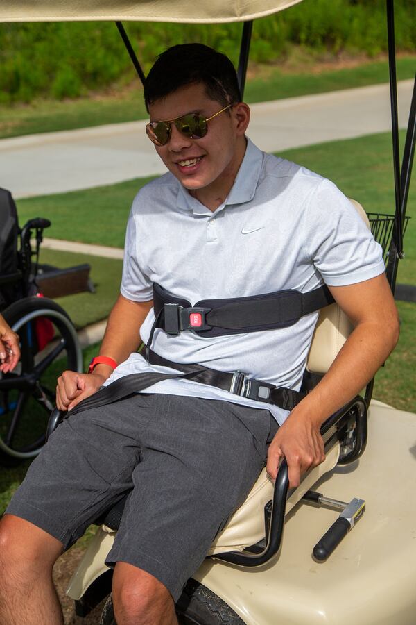 Mak Yost gets settled into the Solo Rider adaptive golf cart that helps him stand and hit the golf ball. PHIL SKINNER FOR THE ATLANTA JOURNAL-CONSTITUTION.