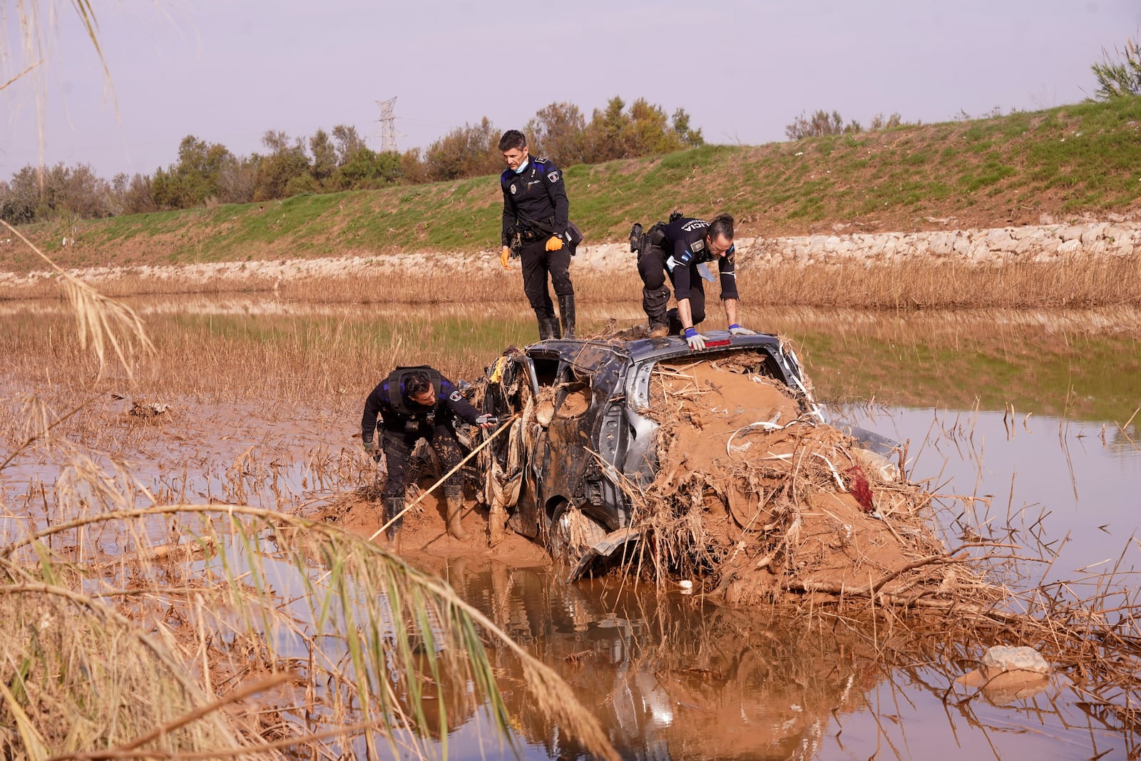 Police officers check car searching for bodies after floods in el Barranco de Chiva on the outskirts of Valencia, Spain, Wednesday, Nov. 6, 2024. (AP Photo/Alberto Saiz)