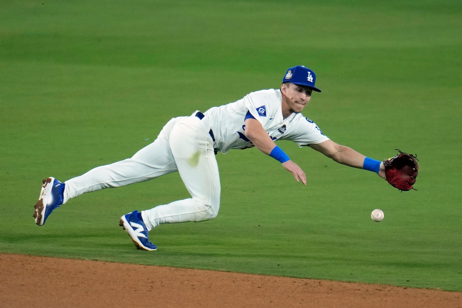 Los Angeles Dodgers shortstop Tommy Edman dives for a single by New York Yankees' Austin Wells during the sixth inning in Game 1 of the baseball World Series, Friday, Oct. 25, 2024, in Los Angeles. (AP Photo/Julio Cortez)