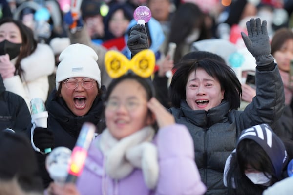 Participants react after hearing the news of South Korean President Yoon Suk Yeol's impeachment outside the National Assembly in Seoul, South Korea, Saturday, Dec. 14, 2024. (AP Photo/Lee Jin-man)