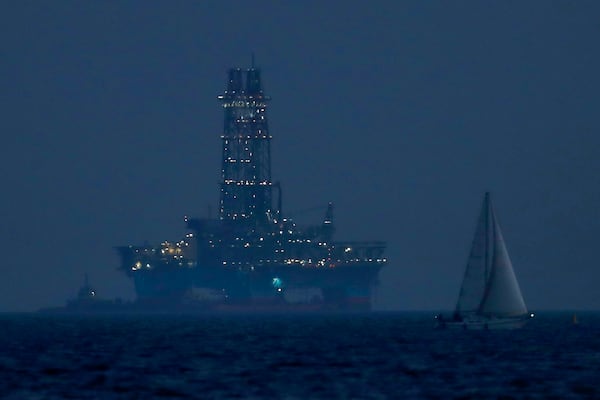 FILE - An offshore drilling rig is seen in the waters off Cyprus' coastal city of Limassol, on July 5, 2020 as a sailboat sails in the foreground. (AP Photo/Petros Karadjias, File)