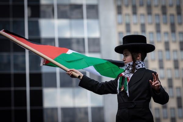 A young orthodox jewish boy waves a Palestinian flag in Foley Square, outside the Manhattan federal court, prior to the deportation case of Mahmoud Khalil, Wednesday, March 12, 2025, in New York. (AP Photo/Stefan Jeremiah)