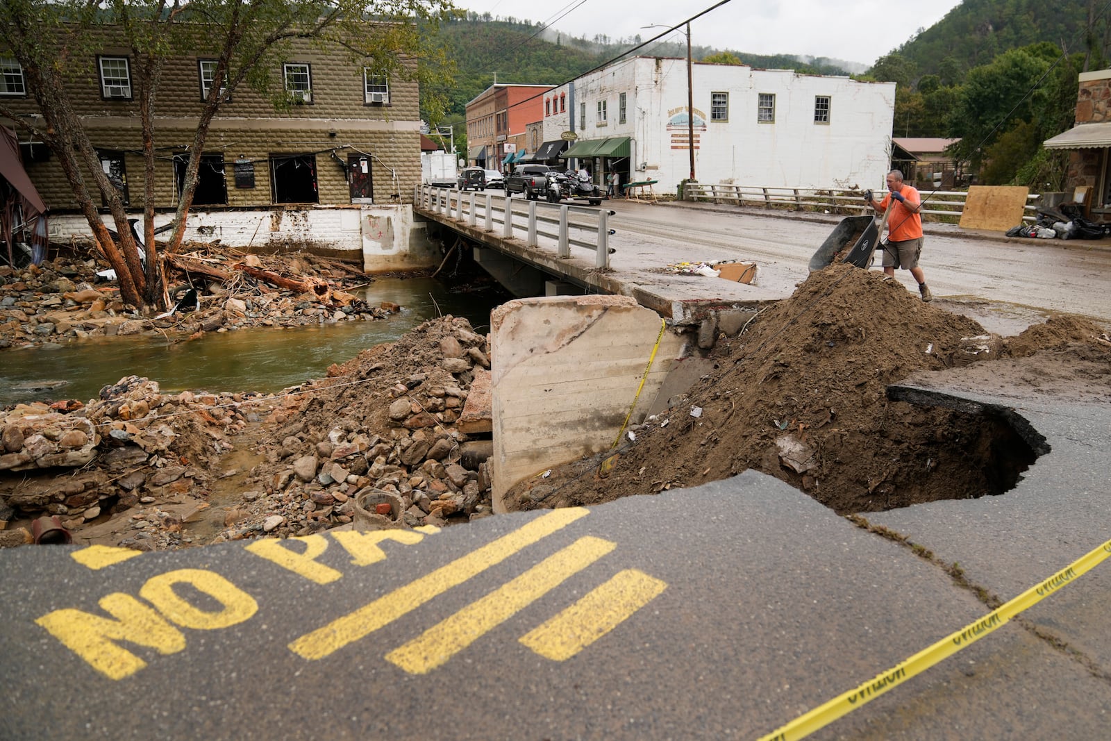 Len Frisbee dumps a wheelbarrow of dirt as he helps with clean up in the aftermath of Hurricane Helene Tuesday, Oct. 1, 2024, in Hot Springs, N.C. (AP Photo/Jeff Roberson)